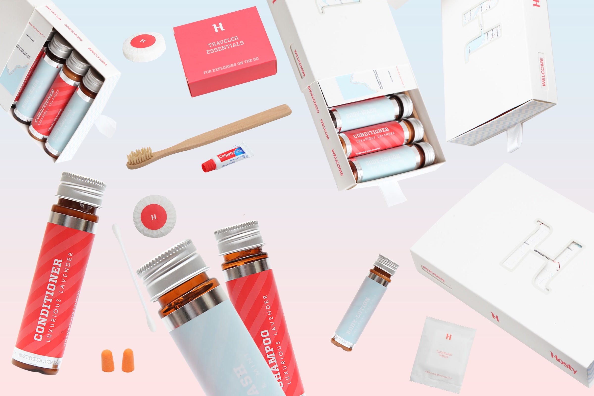The complete Hosty traveler-essentials system arranged with drawer boxes, amber bottles, toothbrush, toothpaste, soap, wipes, and earplugs