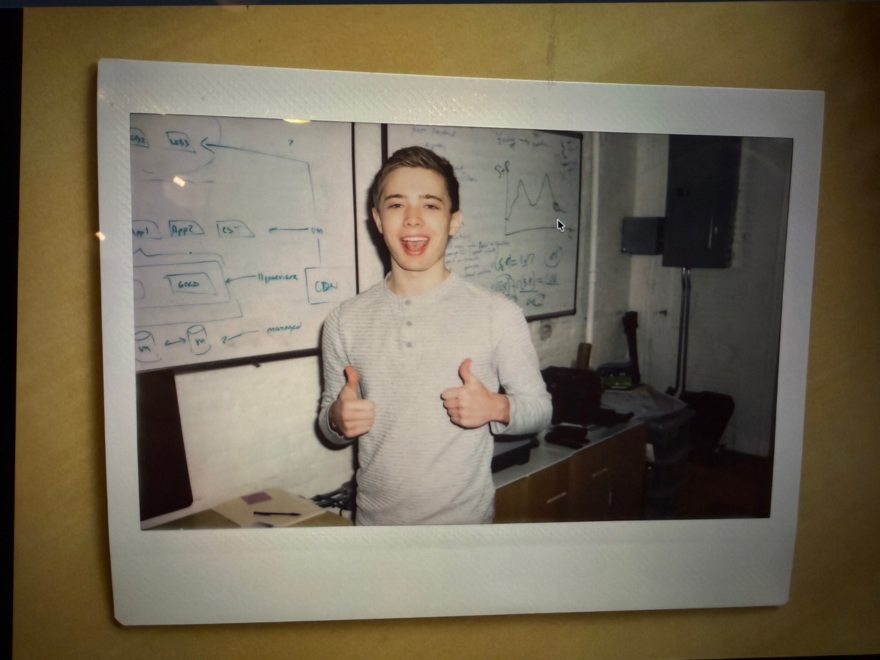 Connor Lee giving two thumbs up in front of whiteboards in Betterment's SoHo office