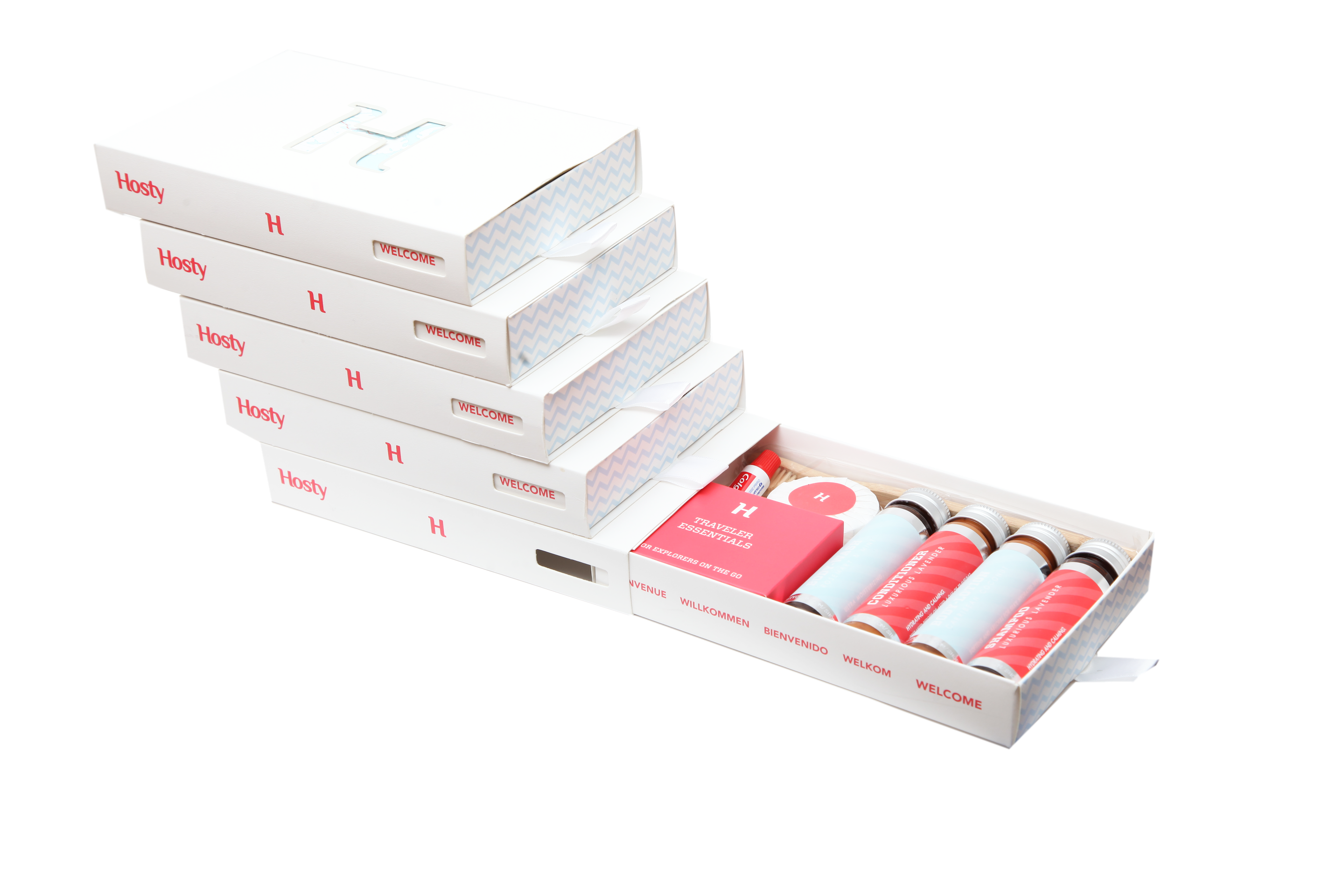 A stack of final white Hosty drawer boxes with one drawer open to reveal the complete guest amenity set